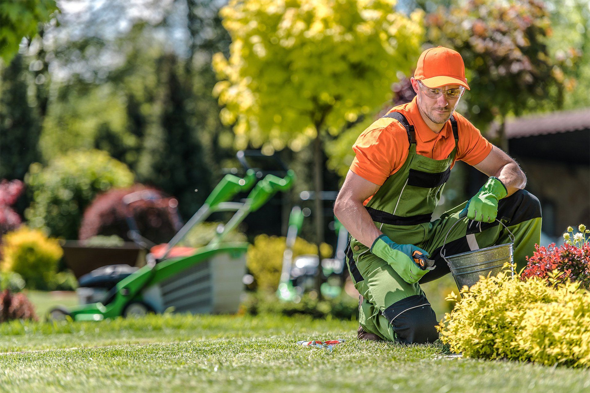 Jardinero dando mantenimiento al césped de un jardín con cortadora de zacate